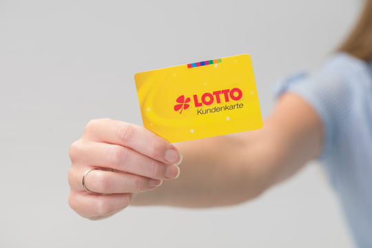 Frau hält Saartoto Kundenkarte in der Hand